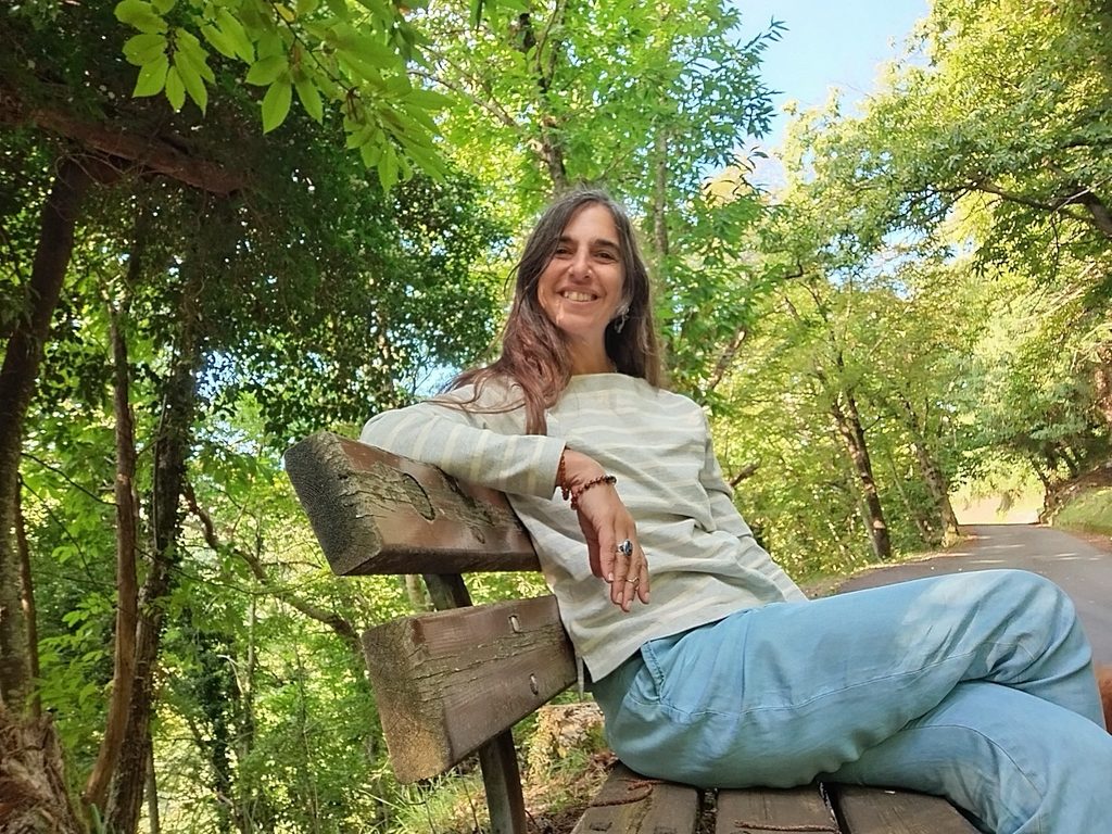 Sobre mi Sole Di Gregorio sentada en un banco rodeada de naturaleza