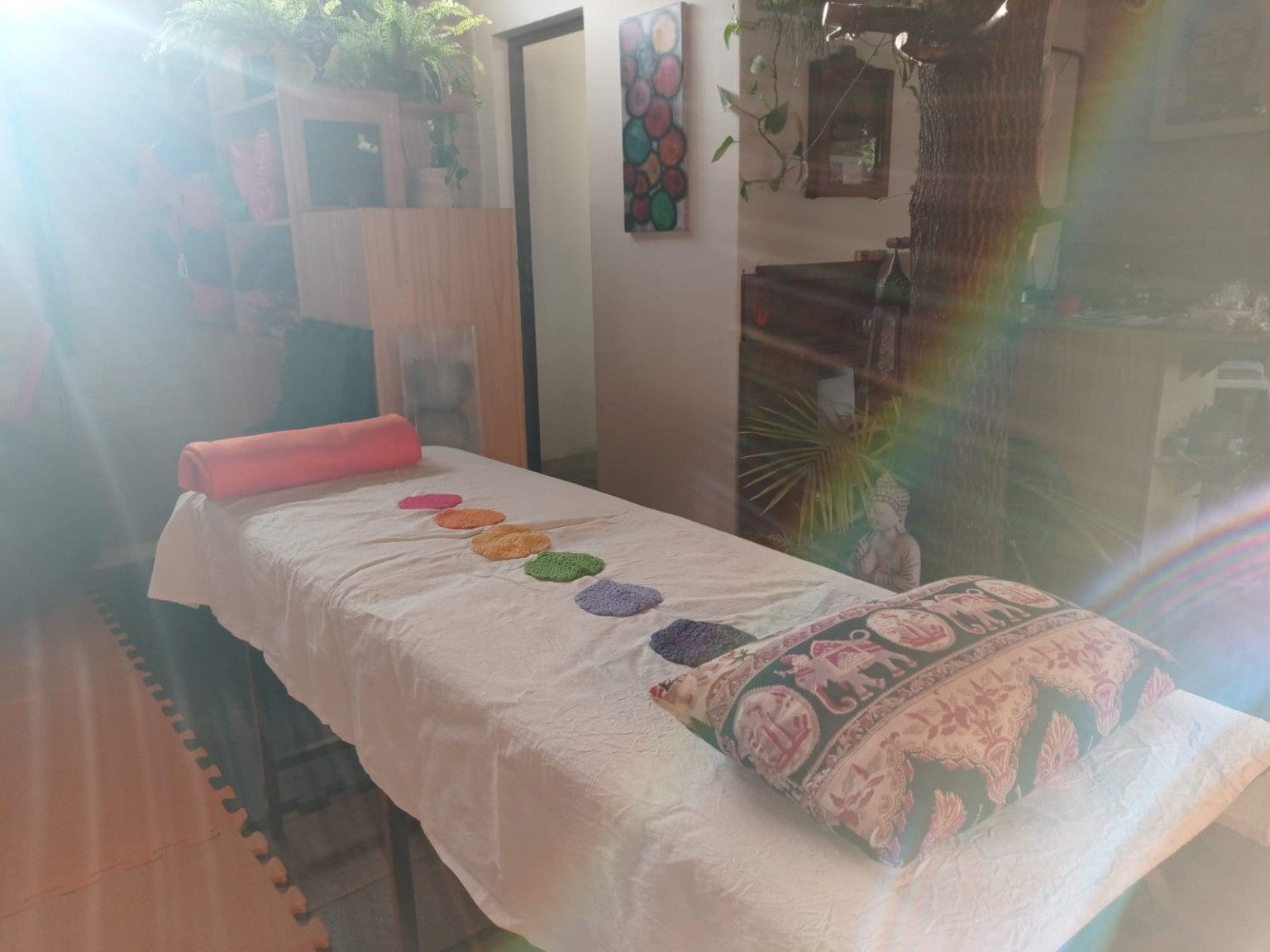 Reiki y armonización energética Camilla preparada con luz natural y un arcoíris en Namasté Ashram