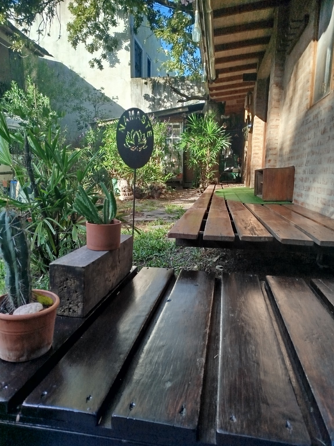 Galería exterior de Namasté Ashram, plantas y símbolo de loto